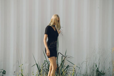 Side view of woman standing against wall