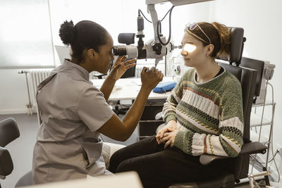Eye care professional examining patient's eye in clinic