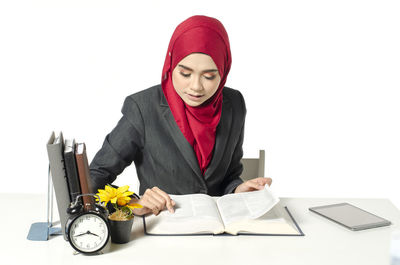 Young woman using smart phone against white background