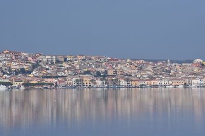 Aerial view of townscape by sea against clear sky