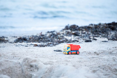 Toy car on rock at beach