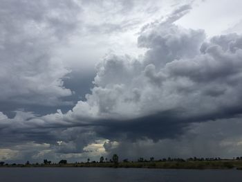 Scenic view of field against cloudy sky