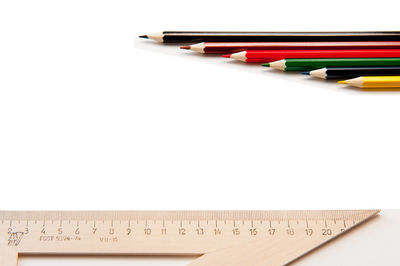 High angle view of pencils on table against white background