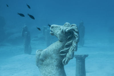 Underwater photography of ancient looking stature area at coastline of cyprus.