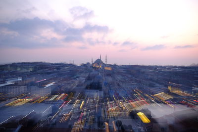 High angle view of illuminated city against sky at sunset