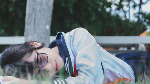 Close-up of woman sleeping on field