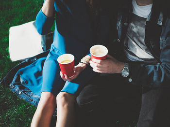 Midsection of woman holding coffee cup