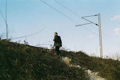 Man standing on field against sky