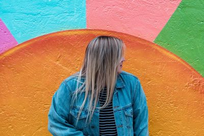 Woman standing against multi colored wall