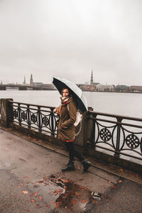 Portrait of man standing by railing against sky