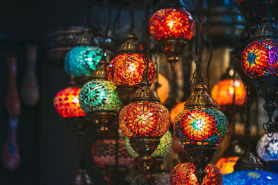 Illuminated lanterns hanging in store for sale