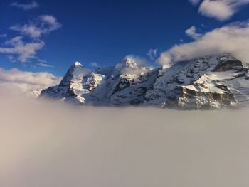Scenic view of snowcapped mountains amidst cloudscape against sky