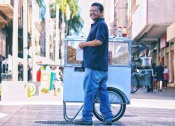 Portrait of man selling food on footpath in city