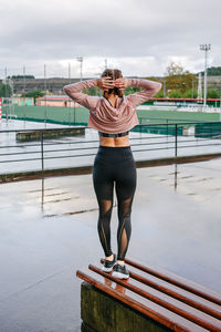 Full length of young woman standing on railing