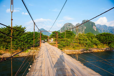 Bridge amidst plants and trees against sky