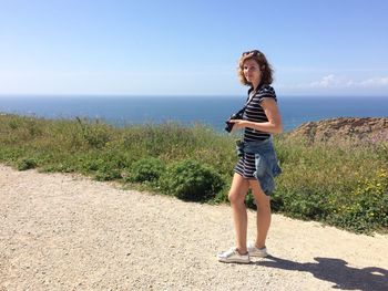 Portrait of a young woman standing on road