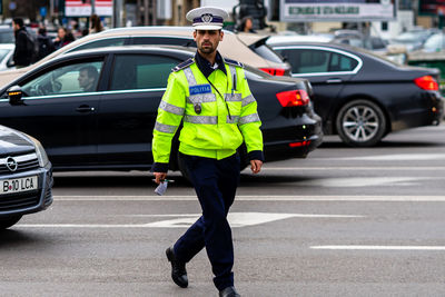 Full length portrait of man standing on road