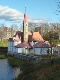 Buildings by lake against sky