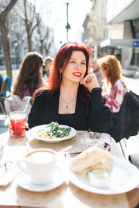 Portrait of young woman having food at restaurant