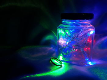 Close-up of illuminated glass jar on table
