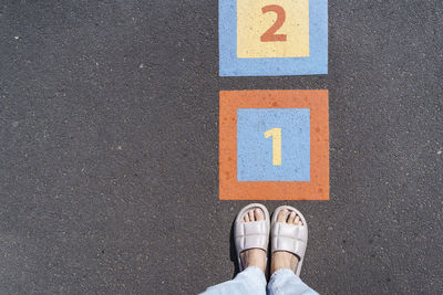 Legs of woman by number on footpath