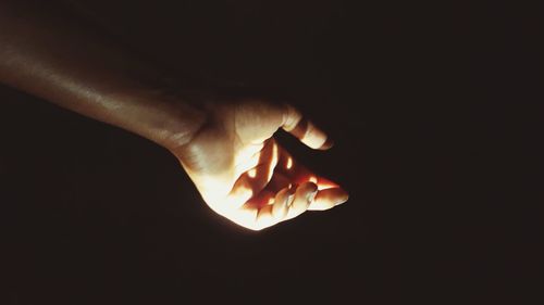 Close-up of hand against illuminated background