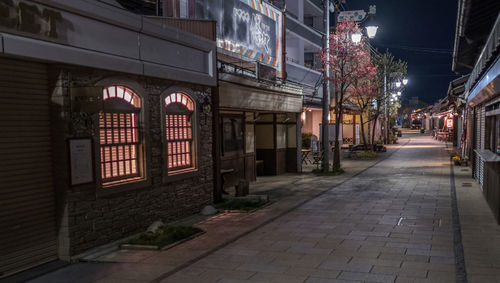 Street amidst buildings at night