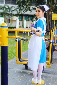 Side view of woman standing against yellow umbrella