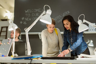 Confident multi-ethnic colleagues working at desk in creative office