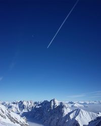 Scenic view of snowcapped mountains against clear blue sky