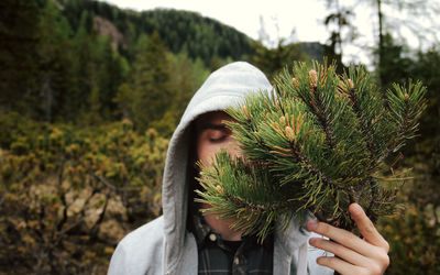 Close-up of young woman against plants