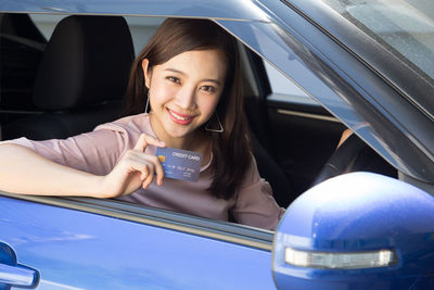 Portrait of smiling young woman in car