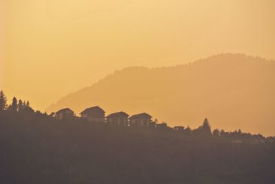 Silhouette buildings against sky during sunset