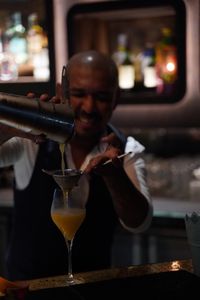 Bartender pouring drink at bar