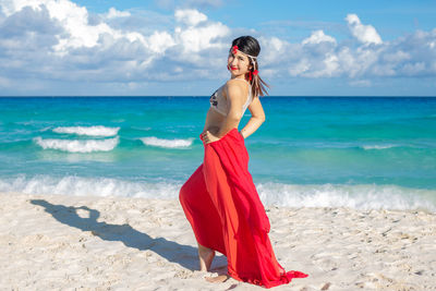 Woman standing on beach against sky