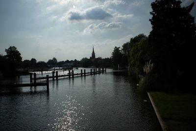 Scenic view of river by trees against sky
