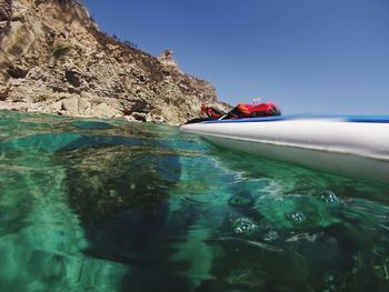 Scenic view of rocks in sea against clear sky