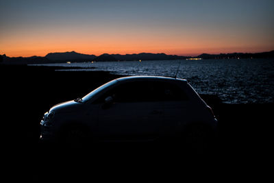 Car on land against sky during sunset