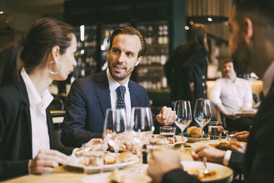 Business coworkers talking while having lunch at restaurant
