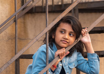 Portrait of happy girl holding railing