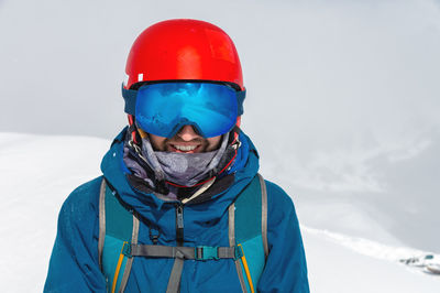 Cheerful skier looking at camera before starting to skiing. happy man enjoying holiday in winter