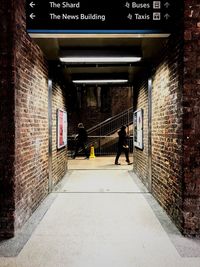 People walking on illuminated walkway