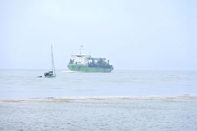 Ship sailing on sea against clear sky