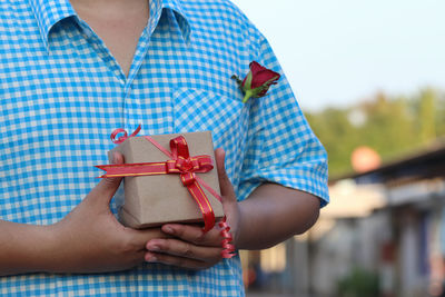 Midsection of woman holding camera in box