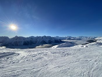 Scenic view of snowcapped mountains against blue sky