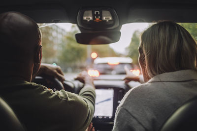 Rear view of couple traveling through car