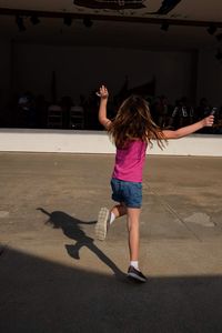 Rear view of woman jumping on the floor