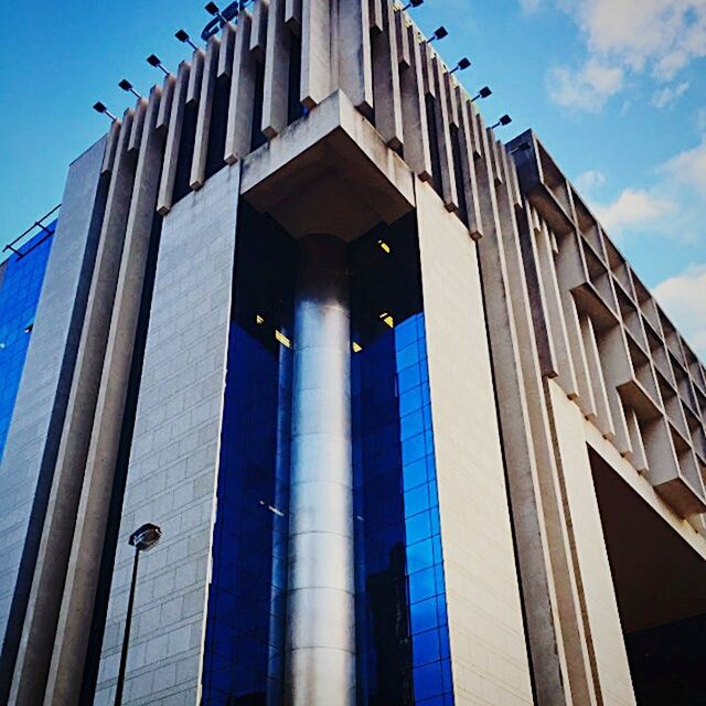 low angle view, architecture, built structure, building exterior, blue, building, sky, street light, window, residential building, lighting equipment, city, clear sky, outdoors, residential structure, day, modern, no people, in a row, sunlight