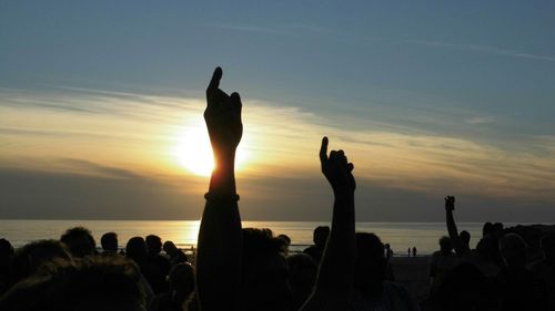 Silhouette of people on beach at sunset