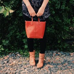 Low section of woman wearing boot standing outdoors